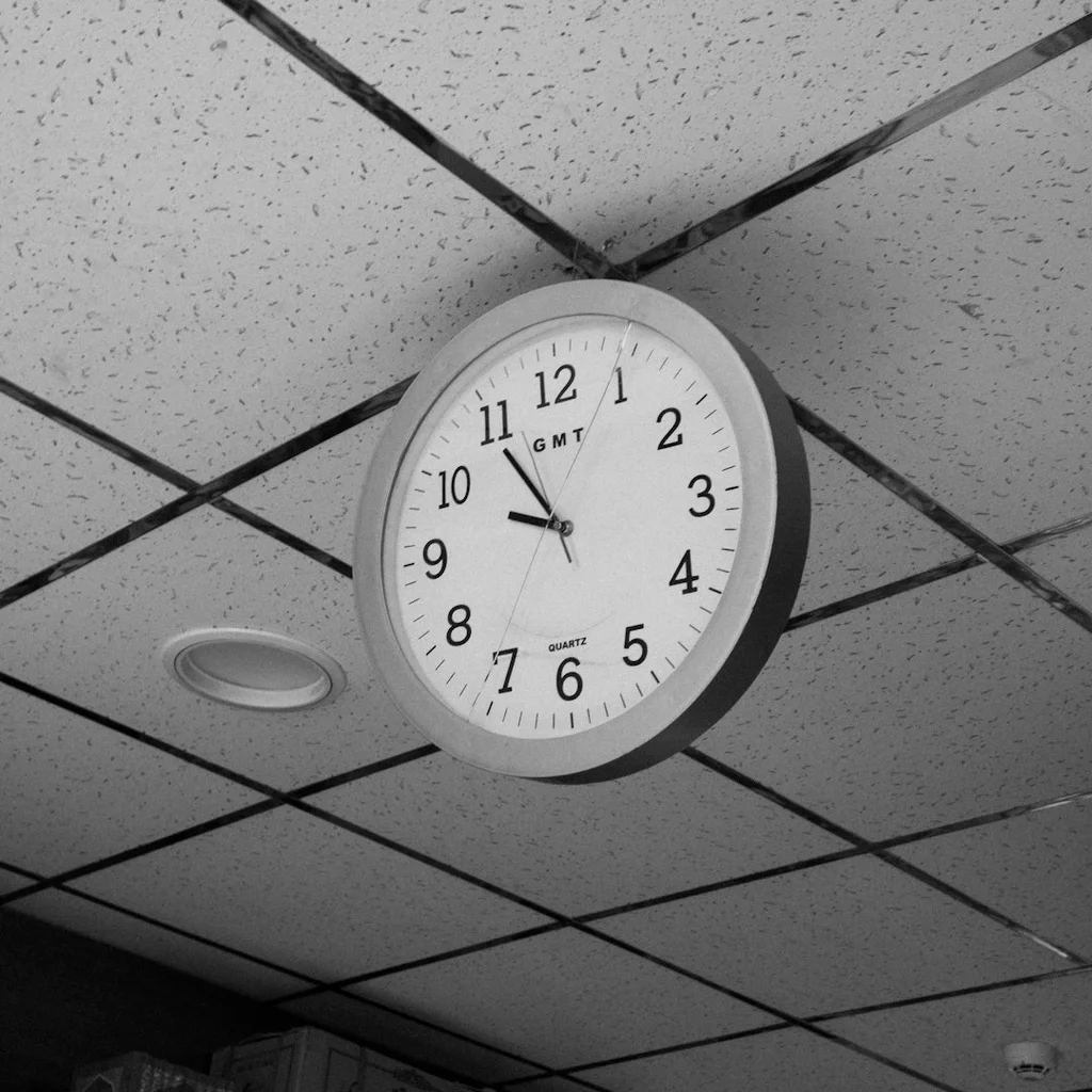 A clock hanging from the ceiling of a room - productivity tips
