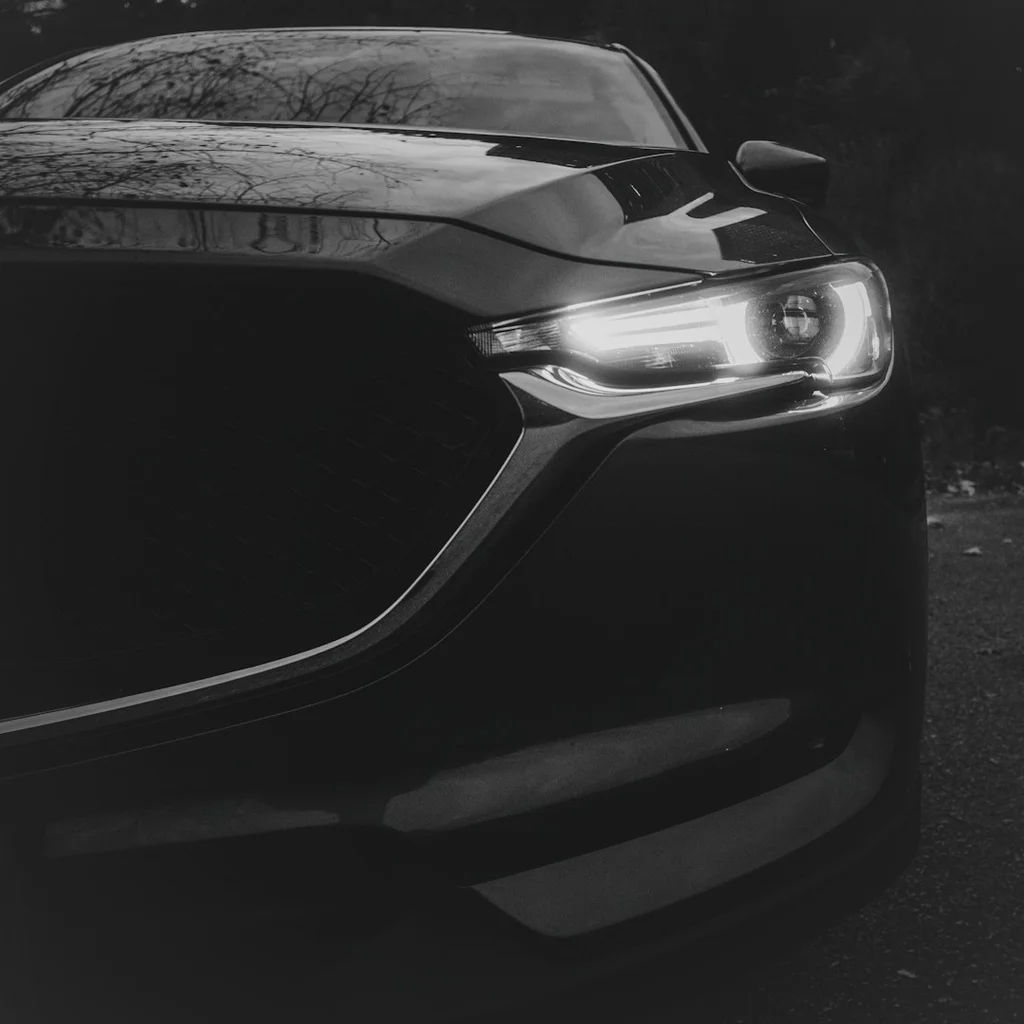 Close-up of a dark car with headlights on - Todoist vs the **Features 3 productivity app**