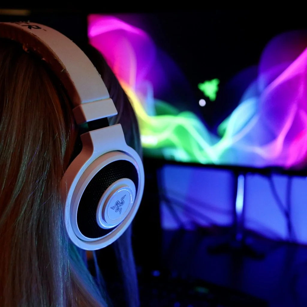 Close-up view of a sleek wireless gaming headset resting on a gaming keyboard, highlighting its modern design and vibrant colors.