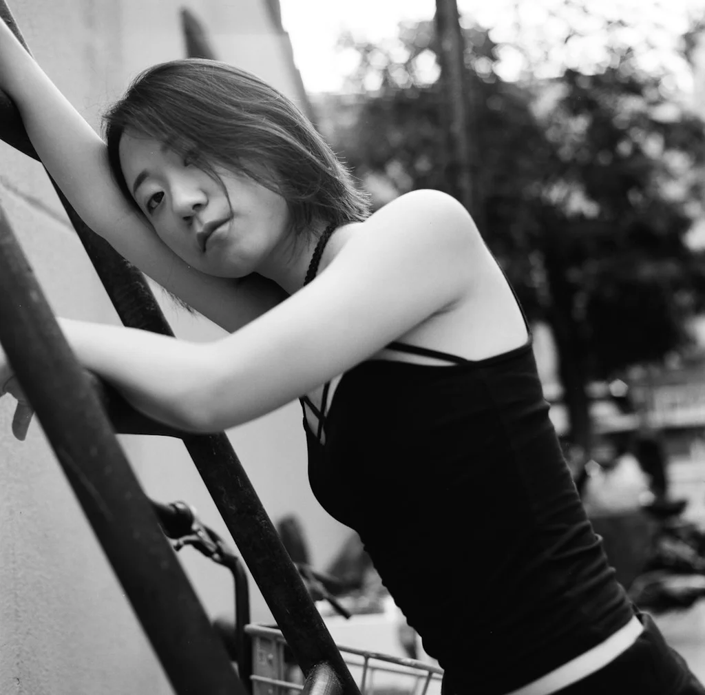 Michelle Yeoh draped in a vibrant green robe, embodying an enchanting presence reminiscent of Madame Morrible.